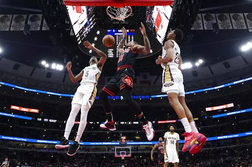 Chicago Bulls forward DeMar DeRozan, center, scores a basket between New Orleans Pelicans forward Herbert Jones, left, and guard Trey Murphy III., during the first half of an NBA basketball game Wednesday, Nov. 9, 2022, in Chicago. (AP Photo/Nam Y. Huh)