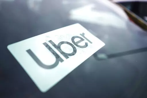 An Uber sign is displayed inside a car in Palatine, Ill., Thursday, Feb. 10, 2022. The U.S. Department of Labor is proposing a new rule on employee classifications, saying workers have incorrectly been deemed independent contractors, which hurts their rights.  The department said Tuesday, Oct. 11,  that misclassifying workers as independent contractors instead of employees denies employees' protections under federal labor standards, promotes wage theft, allows certain employers to gain an unfair