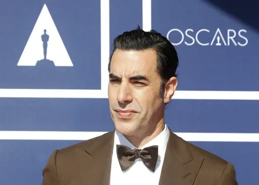 In this April 26, 2021 file photo, Sacha Baron Cohen arrives to attend a screening of the Oscars in Sydney, Australia.  Cohen has dropped his lawsuit against a Massachusetts cannabis dispensary that used an image of his character Borat on a billboard without his permission.  A document filed in Boston federal court on Tuesday, May 17, 2022, said the two sides have agreed to dismiss the case brought last year by the “Borat” star.  (AP Photo/Rick Rycroft, File)