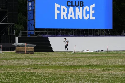 A person walks near a stage at France's house at Parc de la Villette ahead of the 2024 Summer Olympics, Tuesday, July 23, 2024, in Paris, France. (AP Photo/Natacha Pisarenko)