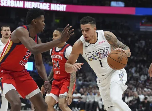 Denver Nuggets forward Michael Porter Jr., right, drives to the basket as New Orleans Pelicans center Yves Missi defends in the first half of an NBA basketball game Wednesday, Feb. 5, 2025, in Denver. (AP Photo/David Zalubowski)