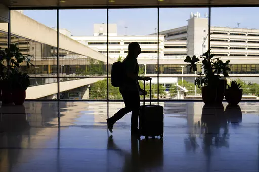 A traveler moves through the Philadelphia International Airport ahead of the Independence Day holiday weekend in Philadelphia, Friday, July 1, 2022.  The concept of “going home for the holidays” changes throughout your life, and many millennials are currently going through that transition. (AP Photo/Matt Rourke, File)