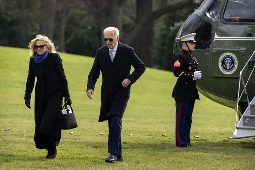 President Joe Biden and first lady Jill Biden walk across the South Lawn of the White House, Thursday, Jan. 2, 2025, in Washington, after returning from Camp David. (AP Photo/Mark Schiefelbein)