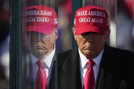 Republican presidential nominee former President Donald Trump is reflected in the bullet proof glass as he finishes speaking at a campaign rally in Lititz, Pa., Nov. 3, 2024. (AP Photo/Matt Rourke, File)