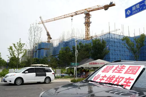 A car with a sign that reads, "Country Garden homeowners rights protections car," is parked near homeowners camping outside the Country Garden One World City project under construction on the outskirts of Beijing, Thursday, Aug. 17, 2023. China's government is trying to reassure jittery homebuyers after the major real estate developer missed a payment on its multibillion-dollar debt, reviving fears about the industry's shaky finances and their impact on the struggling Chinese economy. (AP Photo/