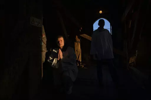 Retired policeman, Volodymyr Ilnytskyi, 55, prays before ringing the bell of the Latin Cathedral in Lviv, western Ukraine, Thursday, March 24, 2022. (AP Photo/Nariman El-Mofty)