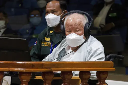 In this photo released by the Extraordinary Chambers in the Courts of Cambodia, Khieu Samphan, right, the former head of state for the Khmer Rouge, sits in a courtroom during a hearing at the U.N.-backed war crimes tribunal in Phnom Penh, Cambodia, Thursday, Sept. 22, 2022. The international court convened in Cambodia to judge the brutalities of the Khmer Rouge regime that caused the deaths of an estimated 1.7 million people in the 1970s ends its work Thursday after spending $337 million and 16 