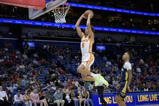 Atlanta Hawks guard Dyson Daniels (5) goes for an open dunk against New Orleans Pelicans guard Jordan Hawkins, right, during the second half of an NBA basketball game in New Orleans, Sunday, Nov. 3, 2024. (AP Photo/Matthew Hinton)