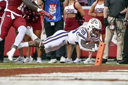 LSU running back Caden Durham (29) dives into the end zone for a touchdown against Arkansas during the first half of an NCAA college football game Saturday, Oct. 19, 2024, in Fayetteville, Ark. (AP Photo/Michael Woods)