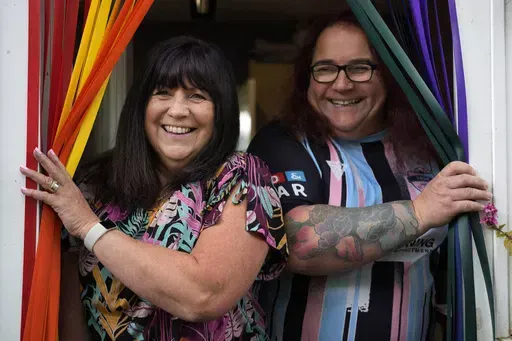 Avril Clark, left, and Lucy pose for a photograph during an interview at their house in London, Tuesday, June 11, 2024. Avril Clark operates the group Distinction Support, a U.K.-based global online network that helps people whose partner went through or is undergoing a gender transition. Her spouse, a British soccer referee at the time, came out publicly as transgender in 2018, changed her name to Lucy and brought the couple much attention. Avril Clark says that until then, they kept their arra