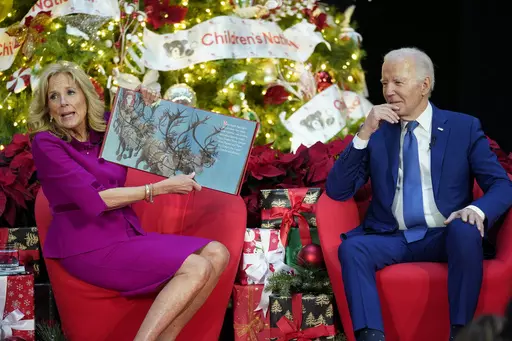 First lady Jill Biden, accompanied by President Joe Biden, reads "Twas the Night Before Christmas" at Children's National Hospital, Friday, Dec. 22, 2023, in Washington. (AP Photo/Evan Vucci)