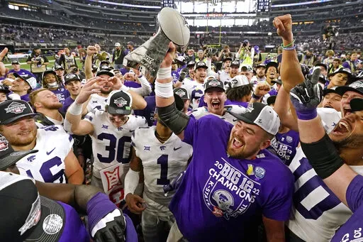 Kansas State players celebrate with the trophy after winning the Big 12 Conference championship NCAA college football game against TCU, Saturday, Dec. 3, 2022, in Arlington, Texas. (AP Photo/LM Otero)