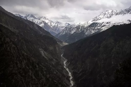 The Sutlej River flows in the valley below the tall snowy peaks in the Kinnaur district of the Himalayan state of Himachal Pradesh, India, March 13, 2023. A new report Tuesday, June 20, from a Nepal-based research organization finds that water security for nearly 2 billion people living downstream of rivers that originate in the Himalayan ranges will likely be threatened by the end of this century due to rapid glacier melt if global warming is not controlled. (AP Photo/Ashwini Bhatia, File)