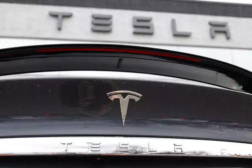 In this April 26, 2020 photo, the company logo shines off the rear deck of an unsold 2020 Model X at a Tesla dealership in Littleton, Colo. Tesla’s sales from April through June 2022 fell to their lowest quarterly level since last fall as supply chain issues and pandemic restrictions in China hobbled production of its electric vehicles. (AP Photo/David Zalubowski, File)