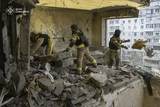 In this photo provided by the Ukrainian Emergency Service, rescuers search for civilians who were killed when a Russian drone hit an apartment building in Sumy, Ukraine, Thursday, Jan. 30, 2025. (Ukrainian Emergency Service via AP)