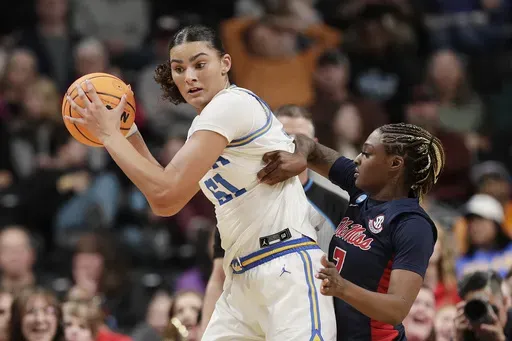 UCLA center Lauren Betts (51) controls the ball while pressured by Mississippi forward Starr Jacobs during the first half in the Sweet 16 of the NCAA college basketball tournament, Friday, March 28, 2025, in Spokane, Wash. (AP Photo/Young Kwak)