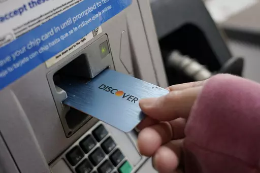 A Discover card is used to pay for gasoline at a Sam's Club in Madison, Miss., July 1, 2021. A combination of inflation, increased interest rates, and the end of pandemic-tied relief, such as the moratorium on student loan payments, has led to record credit card debt, experts say. (AP Photo/Rogelio V. Solis, File)