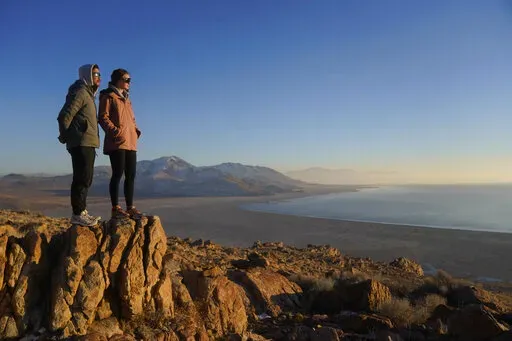 Antelope Island State Park visitors view the the receding edge of the Great Salt Lake Friday, Jan. 28, 2022, at Antelope Island, Utah. The largest natural lake west of the Mississippi is shrinking past its lowest levels in recorded history, raising fears about toxic dust, ecological collapse and economic consequences. But the Great Salt Lake may have some new allies: conservative Republican lawmakers. (AP Photo/Rick Bowmer)