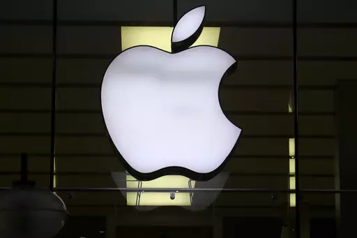The Apple logo is illuminated at a store in the city center of Munich, Germany, Dec. 16, 2020. Apple Inc. is raising the prices for its AppleTV+ streaming and Arcade gaming plans, as well as its bundled Apple One service that includes streaming, music and other subscriptions. (AP Photo/Matthias Schrader, File)