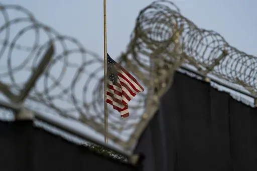 In this Aug. 29, 2021, file photo reviewed by U.S. military officials, a flag flies at half-staff as seen from Camp Justice in Guantanamo Bay Naval Base, Cuba. (AP Photo/Alex Brandon, File)