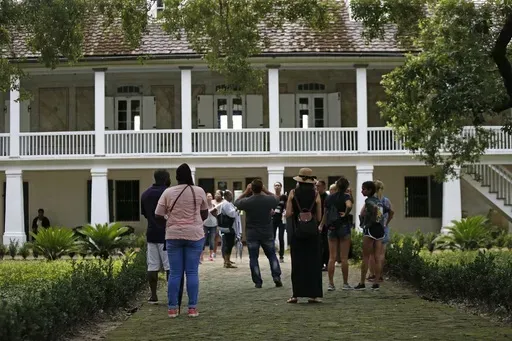 Visitors walk outside the main plantation house at the Whitney Plantation in Edgard, La., July 14, 2017. (AP Photo/Gerald Herbert, File)