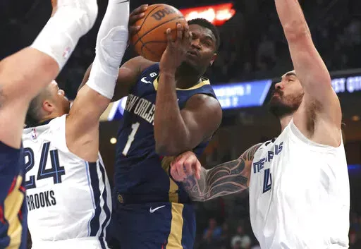 New Orleans Pelicans forward Zion Williamson (1) shoots while defended by Memphis Grizzlies guard Dillon Brooks (24) and center Steven Adams (4) during the first half of an NBA basketball game Saturday, Dec. 31, 2022, in Memphis, Tenn. (AP Photo/Nikki Boertman)