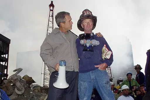 FILE — As rescue efforts continue in the rubble of the World Trade Center in New York, President George W. Bush, left, stands with New York City firefighter Bob Beckwith on a burnt fire truck in front of the World Trade Center during a tour of the devastation, Sept. 13, 2001. Beckwith, who became part of an iconic image of American unity after the Sept. 11 terrorist attacks, has died at age 91. The retired firefighter died Sunday night, Feb. 4, 2024, in hospice care after dealing with cancer i