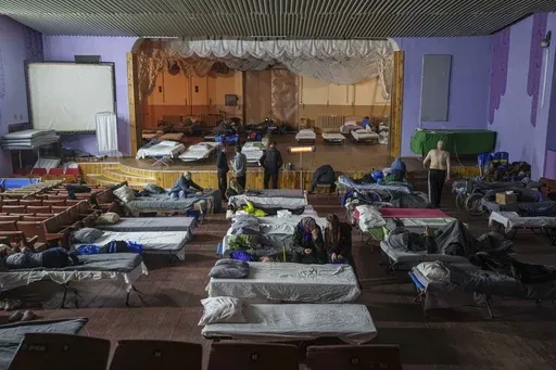 People sit on beds after evacuation from the frontline at a center for displaced people in Pavlohrad, Ukraine, Saturday, Feb. 1, 2024. (AP Photo/Evgeniy Maloletka)Maloletka)