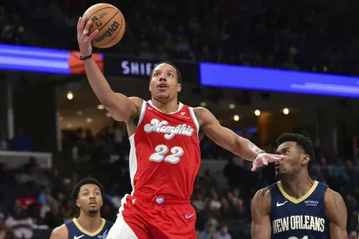 Memphis Grizzlies guard Desmond Bane (22) shoots ahead of New Orleans Pelicans center Yves Missi, right, in the second half of an NBA basketball game Friday, Jan. 24, 2025, in Memphis, Tenn. (AP Photo/Brandon Dill)