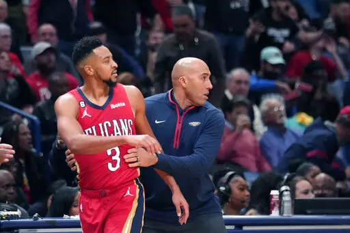 New Orleans Pelicans guard CJ McCollum (3) is restrained by assistant coach Fred Vincent after being called for a technical foul in the second half of an NBA basketball game against the Memphis Grizzlies in New Orleans, Tuesday, Nov. 15, 2022. The Pelicans won 113-102. (AP Photo/Gerald Herbert)