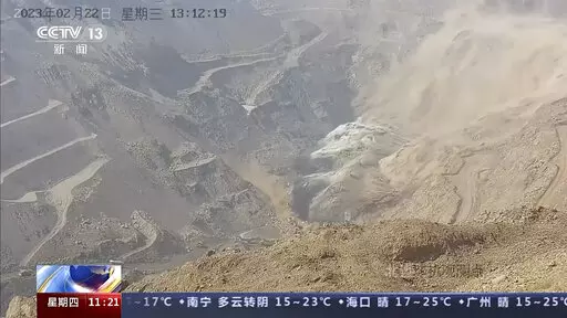 In this image taken from official surveillance camera footage run by China's CCTV, dirt moves down the side of a hill at an open pit mine in Alxa League in northern China's Inner Mongolia Autonomous Region, Wednesday, Feb. 22, 2023. An open pit mine collapsed in China's Inner Mongolia Autonomous Region on Wednesday, killing several people and leaving dozens missing, state media reported. (CCTV via AP)