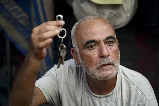 Hassan Nofal, 53, who was displaced by the Israeli bombardment of the Gaza Strip, holds the keys to his home that he was forced to leave with his family at a makeshift tent camp in Khan Younis, southern Gaza Strip, Thursday, July 4, 2024. Over nine months of war between Israel and Hamas, Palestinian families in Gaza have been uprooted repeatedly, driven back and forth across the territory to escape the fighting. Each time has meant a wrenching move to a new location and a series of crowded, temp