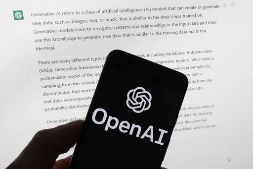 The OpenAI logo is seen on a mobile phone in front of a computer screen displaying output from ChatGPT, on March 21, 2023, in Boston. European lawmakers have rushed to add language on general artificial intelligence systems like ChatGPT as they put the finishing touches on the Western world's first AI rules. (AP Photo/Michael Dwyer, File)