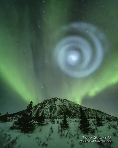 In this photo provided by Todd Salat, northern light enthusiasts got a surprise early April 15, 2023, when something odd was mixed in with the green bands of light dancing above the Donnelly Dome near Delta Junction, Alaska. A light baby blue spiral resembling a galaxy appeared amid the aurora for a few minutes. The spiral was formed when excess fuel that had been released from a SpaceX rocket that launched from California about three hours earlier turned to ice, and then the water vapor reflect