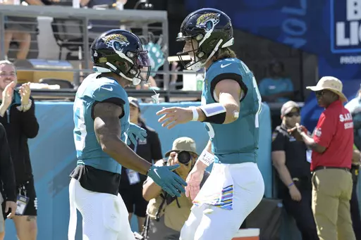 Jacksonville Jaguars wide receiver Christian Kirk, left, and quarterback Trevor Lawrence, right, celebrate Kirk's touchdown catch against the Indianapolis Colts during the first half of an NFL football game, Sunday, Oct. 15, 2023, in Jacksonville, Fla. (AP Photo/Phelan M. Ebenhack)
