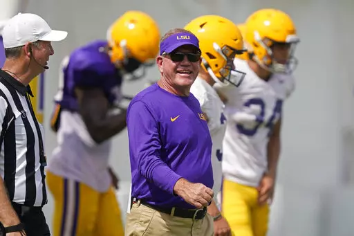 LSU head coach Brian Kelly smiles as he walks across the field during NCAA college football practice in Baton Rouge, La., Wednesday, Aug. 17, 2022. (AP Photo/Gerald Herbert)