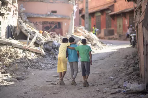 Children walk through the rubble of their town of Amizmiz which was damaged by the earthquake, outside Marrakech, Morocco, Thursday, Sept. 14, 2023. (AP Photo/Mosa'ab Elshamy)