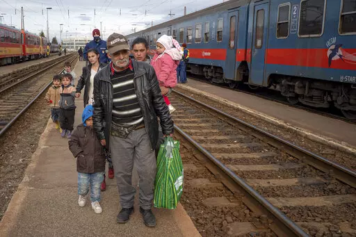 Refugees fleeing the war from neighboring Ukraine walk on a platform after disembarking from a train in Zahony, Hungary, Wednesday, March 2, 2022. At the train station in the Hungarian town of Zahony on Wednesday, more than 200 Ukrainians with disabilities — residents of two care homes in Ukraine's capital of Kyiv — disembarked into the cold wind of the train platform after an arduous escape from the violence gripping Ukraine. (AP Photo/Balazs Kaufmann)
