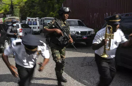 Police escort musicians arriving for the swearing-in ceremony of a transitional council tasked with selecting a new prime minister and cabinet at the Prime Minister's office in Port-au-Prince, Haiti, Thursday, April 25, 2024. (AP Photo/Ramon Espinosa)