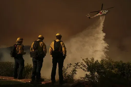 Water is dropped by helicopter on the Palisades Fire in Mandeville Canyon, Jan. 11, 2025, in Los Angeles. (AP Photo/Eric Thayer,File)
