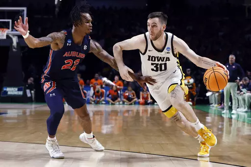 Iowa guard Connor McCaffery (30) drives to the basket as Auburn forward Yohan Traore (21) defends during the second half of a first-round college basketball game in the men's NCAA Tournament in Birmingham, Ala., Thursday, March 16, 2023. Auburn won 83-75. (AP Photo/Butch Dill)