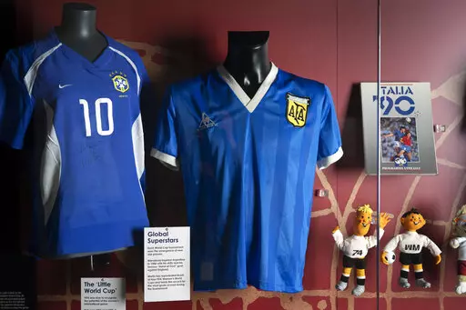 The soccer shirt, center, worn by Argentina's Diego Maradona in the 1986 World Cup quarterfinal against England is displayed at the National Football Museum in Manchester, England Nov. 26, 2020. The shirt worn by Diego Maradona when he scored the controversial “Hand of God” goal against England in the 1986 World Cup is for sale for the first time. Auctioneer Sotheby’s said Wednesday, April 6, 2022 that the jersey could fetch more than 4 million pounds ($5.2 million) in an online auction th