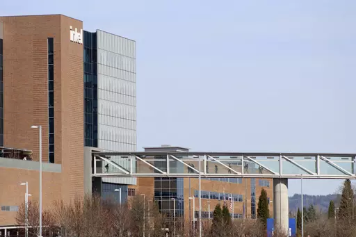 Workers walk on a skybridge to and from a large Intel facility in Hillsboro, Ore., on March 17, 2023. Intel, which produces semiconductor chips, is Oregon's biggest corporate employer. Lawmakers are considering a bill that would allow the governor to expand urban growth boundaries for semiconductor-related industries. (AP Photo/Andrew Selsky)