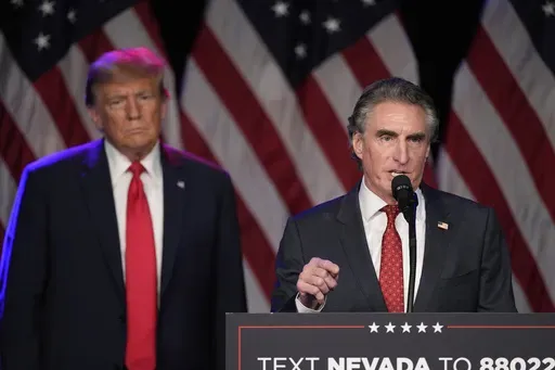 Republican presidential candidate former President Donald Trump listens as North Dakota Gov. Doug Burgum speaks at a caucus night rally in Las Vegas, Feb. 8, 2024. (AP Photo/Mark J. Terrill, File)