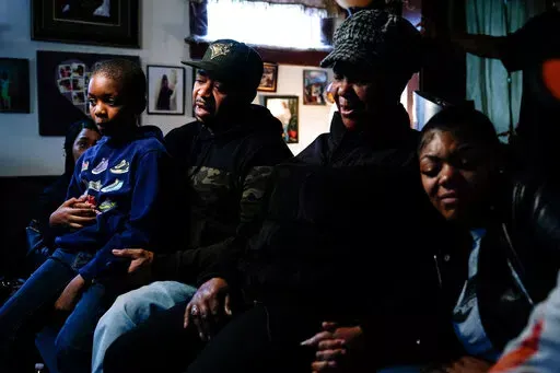 Wayne Jones, center left, accompanied by his aunt JoAnn Daniels, center right, son Donell Jones, left, and daughter Kayla Jones, speaks during an interview with The Associated Press, Monday, May 16, 2022, about his mother, Celestine Chaney, who was killed at the shooting at a supermarket over the weekend, in Buffalo, N.Y. (AP Photo/Matt Rourke)