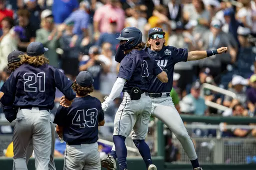 Oral Roberts' Dylan Wipperman, right, gives Blaze Brothers (8) a chest-bump after scoring on a three-run home against TCU in the ninth inning of a baseball game at the NCAA College World Series in Omaha, Neb., Friday, June 16, 2023. (AP Photo/John Peterson)