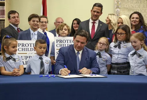 Florida Gov. Ron DeSantis signs the Parental Rights in Education bill, also known as the "Don't Say Gay" bill, at Classical Preparatory School, March 28, 2022, in Shady Hills, Fla. Students and teachers will be able to speak freely about sexual orientation and gender identity in Florida classrooms, provided it’s not part of instruction, under a settlement reached Monday, March 11, 2024, between Florida education officials and civil rights attorneys who had challenged a state law which critics 