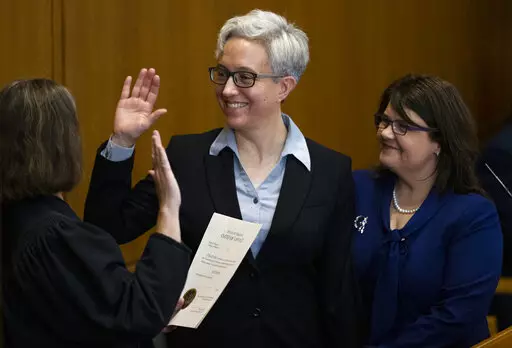 Tina Kotek, center, was accompanied by her wife Aimee Wilson, right, as Kotek was sworn in as Oregon governor at the state Capitol building in Salem, Ore., on Monday, Jan. 9, 2023. (Dave Killen/The Oregonian via AP, Pool)