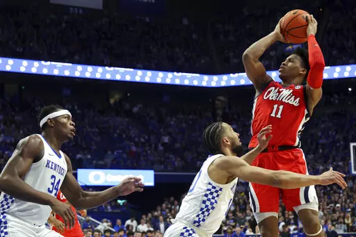 Mississippi's Matthew Murrell (11) shoots while defended by Kentucky's Davion Mintz, middle, and Oscar Tshiebwe (34) during the second half of an NCAA college basketball game in Lexington, Ky., Tuesday, March 1, 2022. (AP Photo/James Crisp)