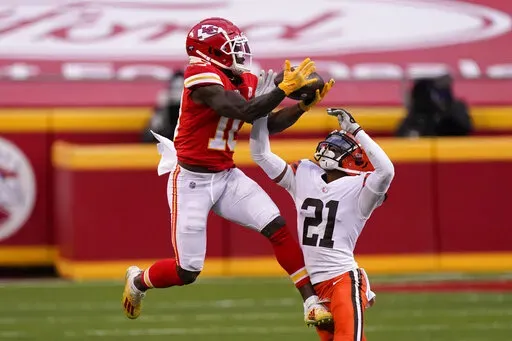 Kansas City Chiefs wide receiver Tyreek Hill makes a catch over Cleveland Browns cornerback Denzel Ward (21) during the second half of an NFL divisional round football game, Sunday, Jan. 17, 2021, in Kansas City. The Kansas City Chiefs traded wide receiver Tyreek Hill to Miami for a package of draft picks on Wednesday, March 23, 2022, and the Dolphins are giving the three-time All-Pro a $120 million, four-year contract extension, a person familiar with the moves told The Associated Press. (AP Ph